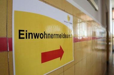 Auf einem gelben Schild steht Einwohnermeldeamt.