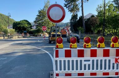 Auf einer Straße stehen ein Sperrschild und eine Warnbake.