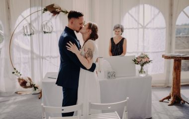 Ein junges Brautpaar küsst sich vor dem Traualtar.