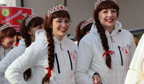 Frauen mit weißen Jacken und einer Krone auf dem Kopf.