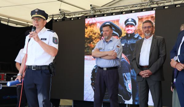 Männer in Polizei-Uniform stehen auf einer Bühne.