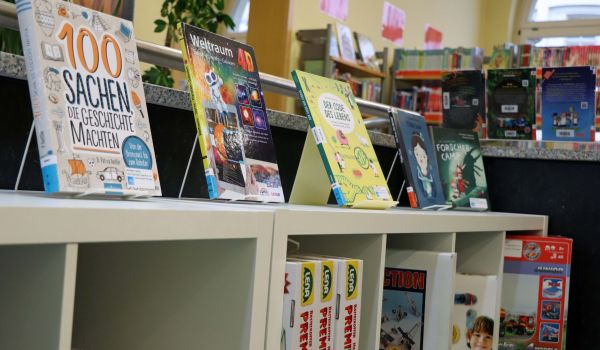 Auf einem Regal sind verschiedene Bücher präsentiert.