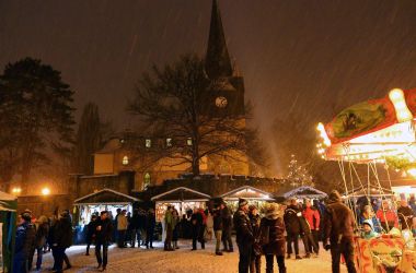 Ein verschneiter Weihnachtsmarkt in Oberlind. Es ist Abend.