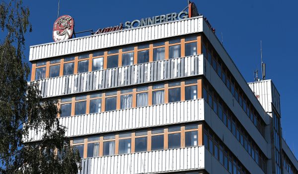 Ein altes Fabrikgebäude. Auf dem Dach steht ein Schild mit der Aufschrift: Sonni Sonneberg. Links davon ist ein Schild mit einer Puppe darauf.