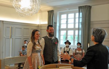 Ein Junges Brautpaar steht vor der Standesbeamtin.