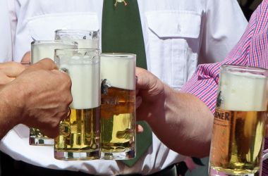 Fünf Menschen halten Biergläser in die Kamera.