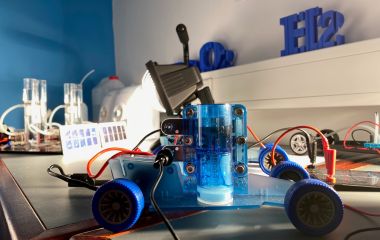 Ein Experimentierauto, welches mit Wasserstoff angetrieben wird, steht auf einem Tisch.