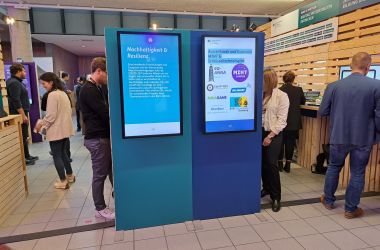 Zwei Info-Monitore auf einer Messe.