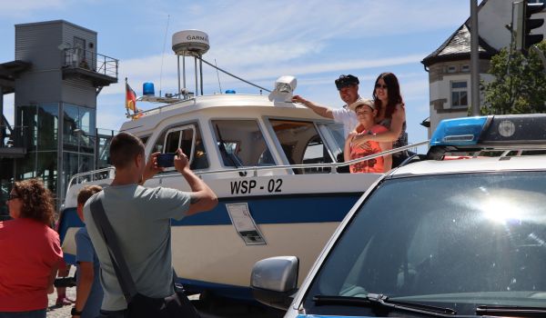 Eine Familie lässt sich auf einem Polizei-Motorboot fotografieren.