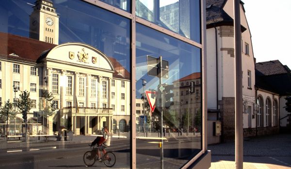 In einer Scheibe spiegelt sich das Rathaus des Stadt Sonneberg.