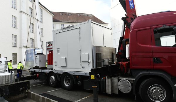 Auf einem LKW steht ein großer weißer Container.
