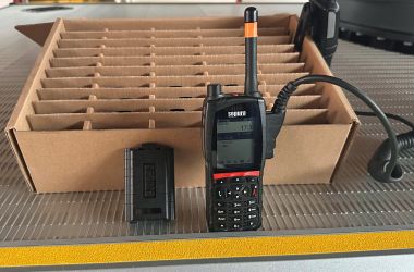 Ein Funksprechgerät und ein Akku dazu stehen vor einem Karton in der Feuerwehr Sonneberg-Mitte.