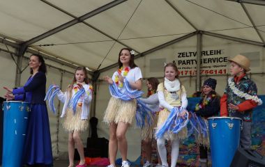 Kinder tanzen auf einer Bühne.