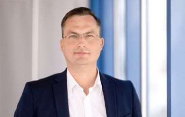 Ein Mann steht vor einem Fenster. Es ist der Wirtschaftsförderer Marco Kuhnt.