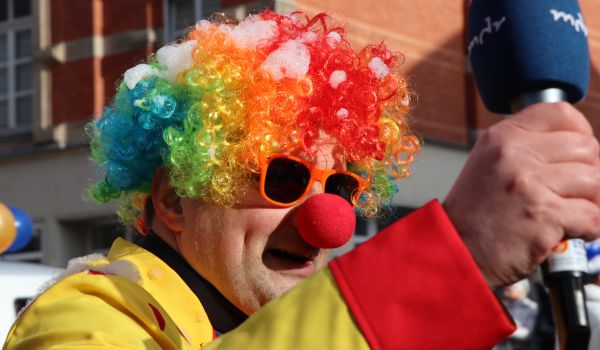 Ein Mann ist als Clown verkleidet. Er hält ein Mikrofon mit der Aufschrift: mdr.