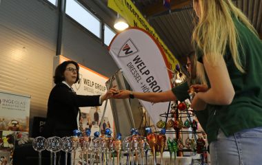 Menschen stehen an einem Messestand mit Glaskugeln.