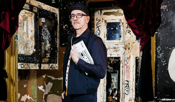 Ein Mann steht vor einer beschmierten Wand mit Fenster.