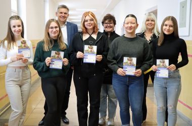 Fünf Jugendliche stehen in einer Reihe. Sie halten einen Flyer mit der Aufschrift: Nachhilfe in den Händen.