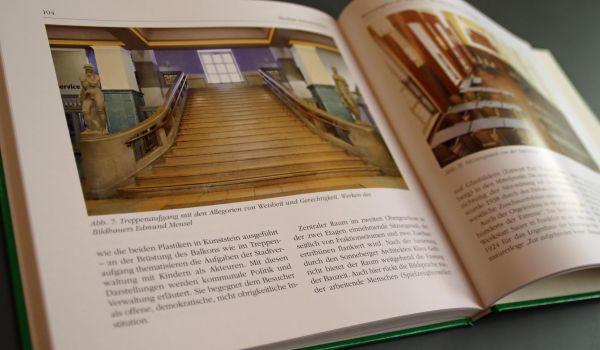 In einem Buch: Ein Bild vom Treppenaufgang des Rathausses Sonneberg mit einem Text darunter.