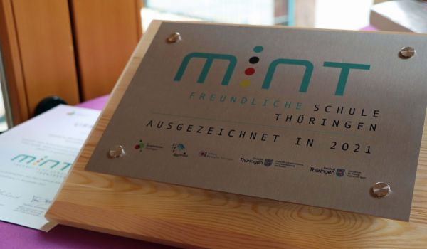 Eine stahlfarbene Plakette mit der Aufschrift: Mint freundliche Schule Thüringen, ausgezeichnet in 2021.