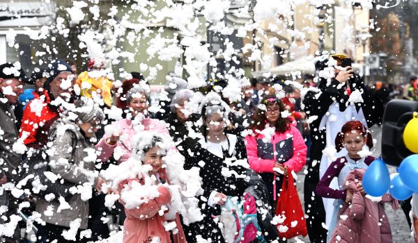 Schaum regnet auf die Zuschauer des Faschingsumzugs.
