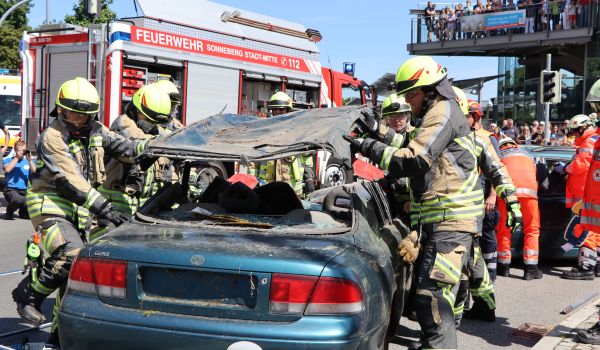 Die Feuerwehr hebt das Dach eines verunfallten Autos an.