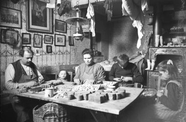 Ein Schwarz-Weiß-Foto zeigt eine Familie die Heimarbeit macht.