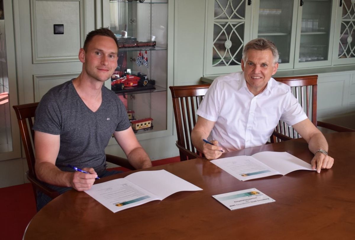 Zwei Männer sitzen an einem Tisch und unterschreiben einen Vertrag. Einer der Männer ist der Bürgermeister Dr. Heiko Voigt.