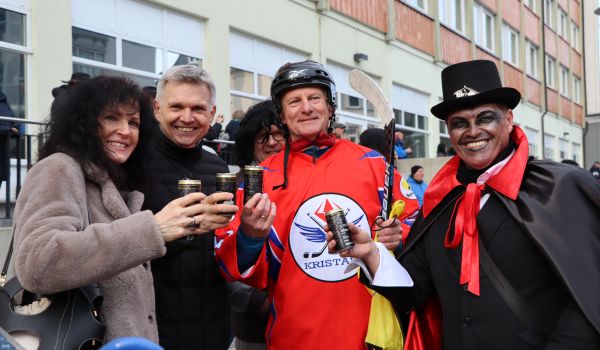 Vier Personen stehen nebeneinander und stoßen an.