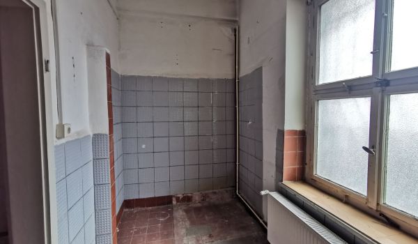 Eine Baustelle in einem Gebäude. An einer Wand wurden Fließen entfernt.