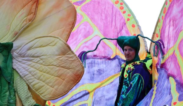 Ein Mann in buntem Schmetterlingskostüm.