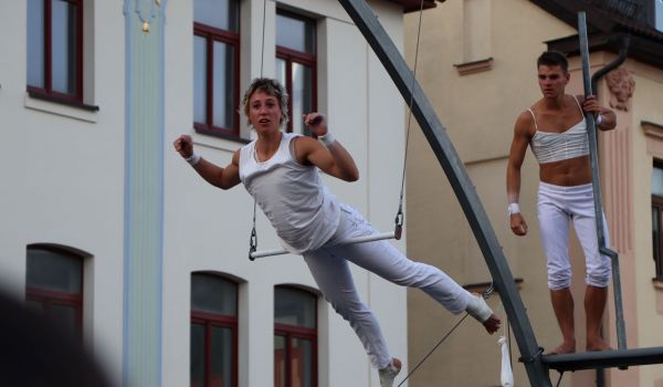 Zwei Artisten turnen in der Innenstadt hoch in der Luft.