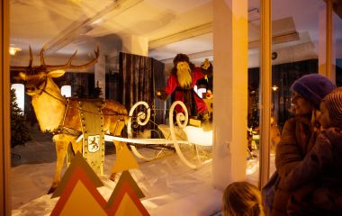 Ein großer Weihnachtsmannschlitten hinter einem Schaufenster.