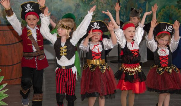 Kinder im Piratenkostüm tanzen auf einer Bühne.