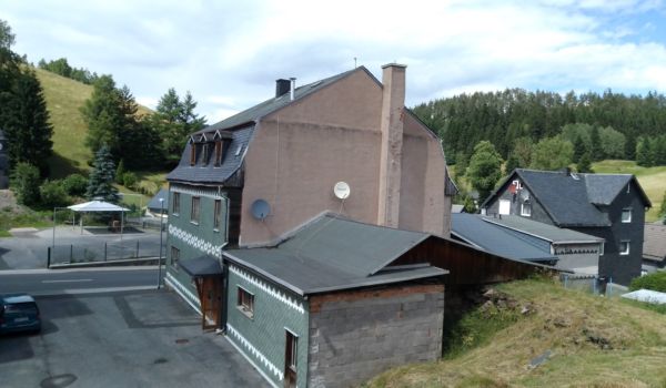 Ein dunkelgrünes Schieferhaus von hinten.