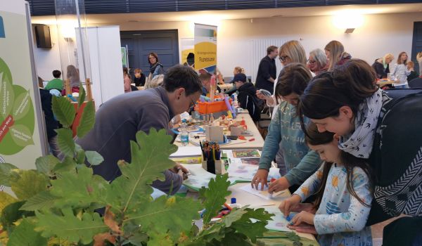 Kinder malen an einem Stand.