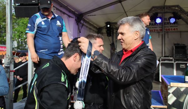 Der Bürgermeister Dr. Voigt hängt den Gewinnern die Medaille um.