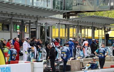 Teilnehemer in Rennfahreranzügen bereiten sich auf das Rennen vor.