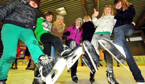 Kinder fahren Schlittschuhe.