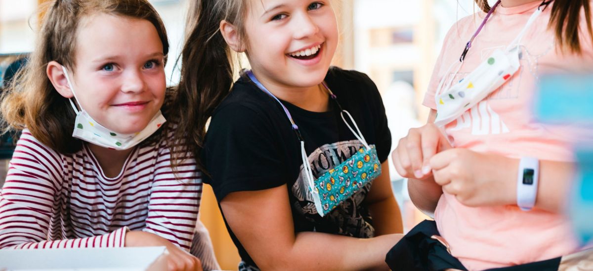 Kinder basteln an einem Tisch.