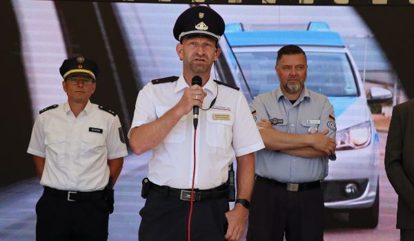 Männer in Uniform stehen auf einer Bühne und begrüßen die Gäste.