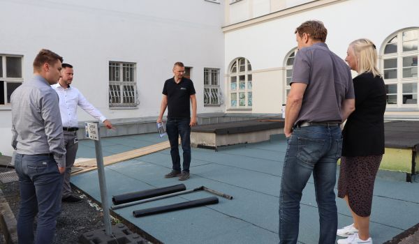 Fünf Personen schauen sich den Stand einer Baustelle an.