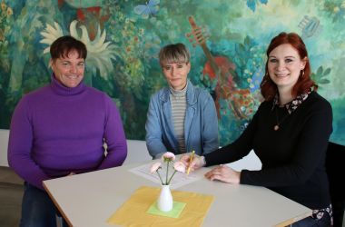 Zwei Frauen und ein Mann sitzen an einem Tisch in der Wolke 14.