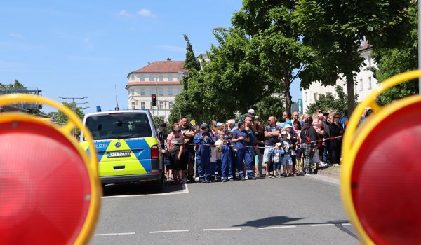 Viele Menschen stehen hinter einer Absprerrung.