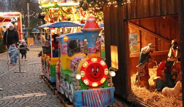 Die Kindereisenbahn umrundet den Weihnachtsbaum und kommt an der Krippe vorbei.