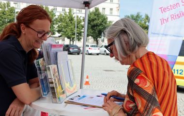 Ein Frau steht an einem Stand und informiert sich.