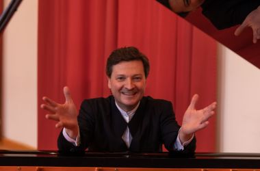 Ein Mann sitzt an einem Flügel.