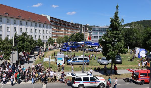 Verschiedene Fahrzeuge stehen auf einer Wiese neben dem Rathaus.