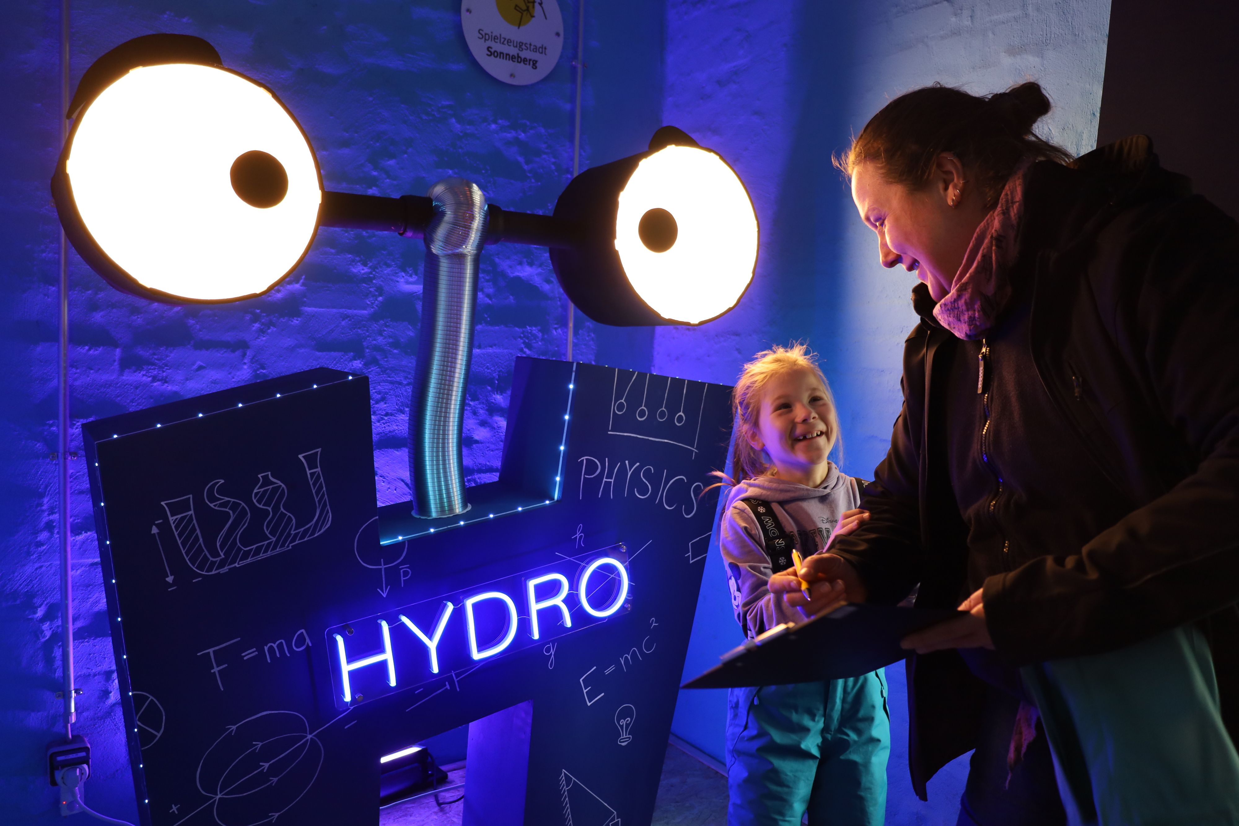 Auf einer H-förmigen Schild leuchtet das Wort ''Hydro'' blau.