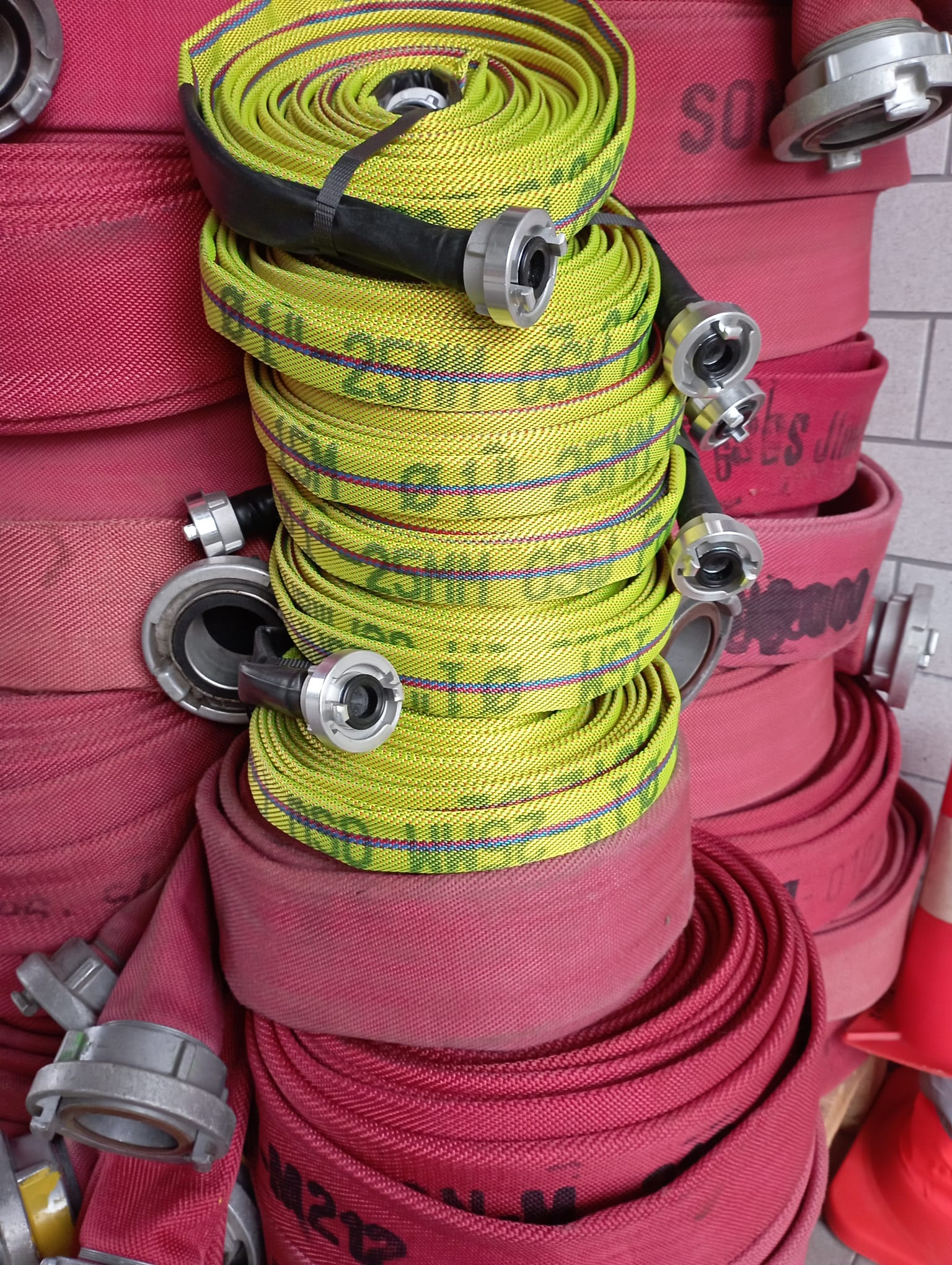 Rote und gelbe aufgewickelte Feuerwehrschläuche sind zu sehen.